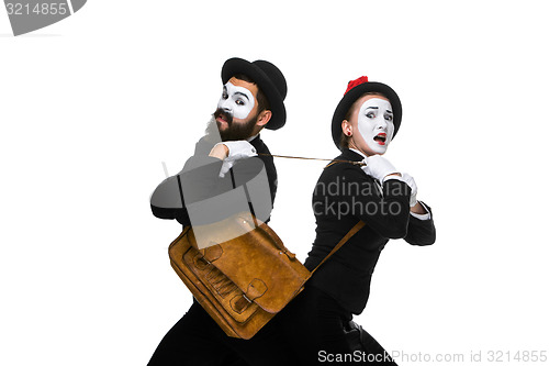 Image of Business man and woman fighting over briefcase