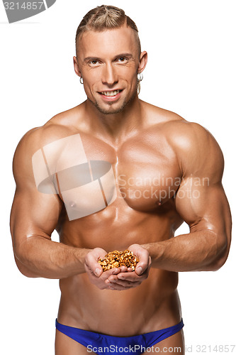 Image of Shaped and healthy body man holding a walnuts,  isolated on white background