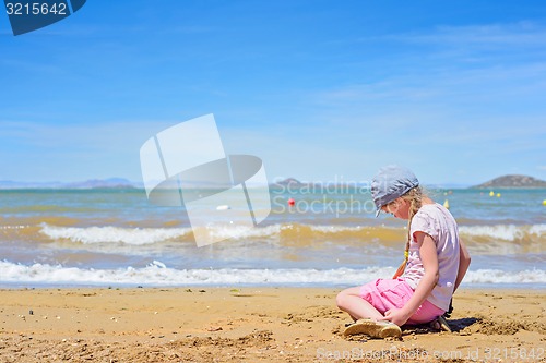 Image of Little girl playing on the beach