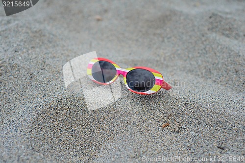 Image of Children\'s striped sunglasses on the sand