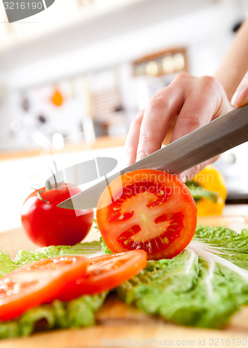 Image of Woman\'s hands cutting tomato