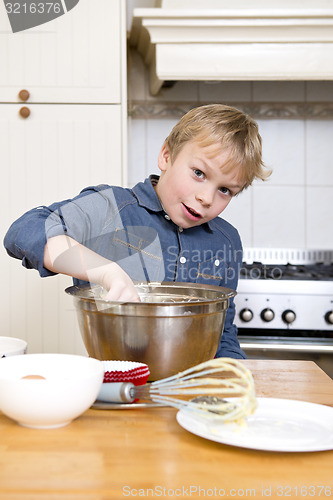 Image of Young boy baking pies in a kitchen