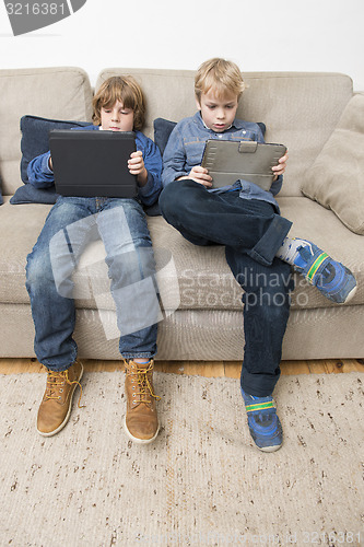 Image of Two boys playing video games on a tablet computer
