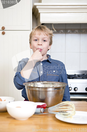 Image of Licking batter from a bowl in a kitchen