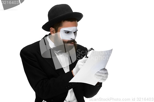 Image of Man with a face mime reading through magnifying glass 