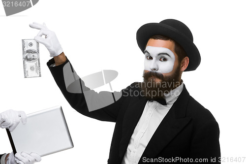 Image of businessman\'s hand in the form of mime extract money from tablet PC