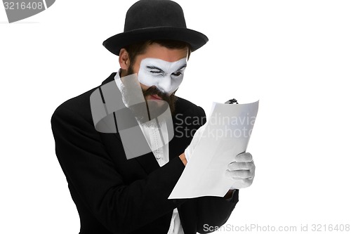 Image of Man with a face mime reading through magnifying glass 