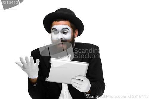 Image of Man with a face mime working on  laptop 