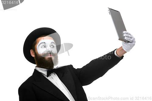 Image of Man with a face mime working on a laptop isolated on a white background. 