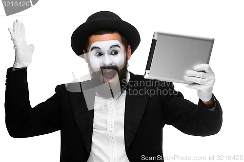 Image of Man with a face mime working on  laptop 