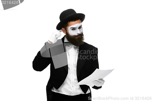 Image of pensive mime as a businessman reading the list of paper 