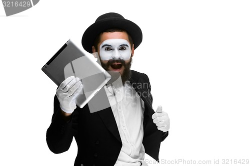 Image of Man with  face mime working a laptop isolated on  white background.