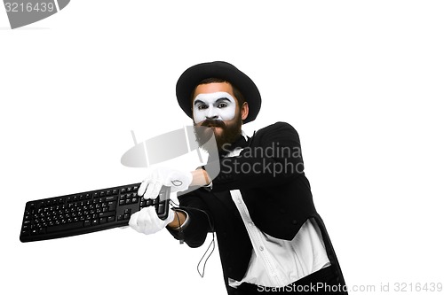 Image of Angry mime as a businessman is destroying  keyboard