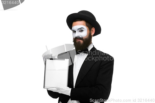 Image of Man with a face mime working on  laptop