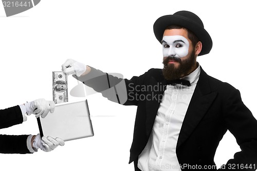 Image of businessman\'s hand in the form of mime extract money from tablet PC