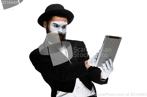 Image of Man with a face mime working on  laptop 