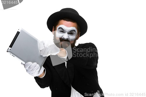 Image of mime as a businessman throws computer in rage.