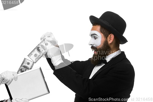 Image of businessman\'s hand in the form of mime extract money from tablet PC