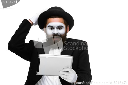 Image of Man with a face mime working on laptop 