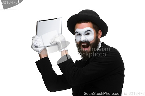 Image of mime as a businessman throws computer in rage.