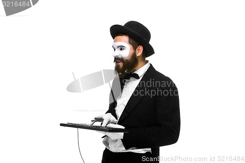 Image of mime as a businessman holdinga keyboard