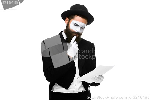 Image of pensive mime as a businessman reading the list of paper 