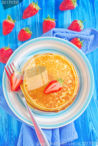 Image of pancakes on plate and fresh strawberries