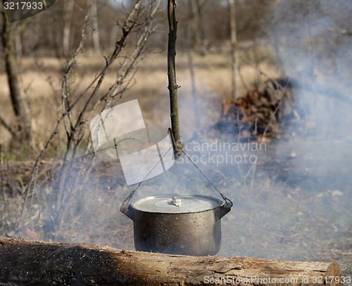 Image of Cooking in sooty cauldron on campfire