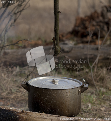 Image of Cooking in old sooty cauldron on campfire