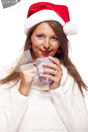 Image of Cold young woman in a Santa hat sipping coffee tea