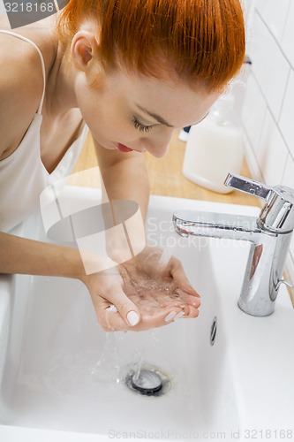 Image of Woman Washing her Face While Looking at the Camera