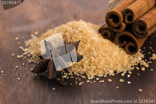 Image of Cinnamon sticks with pure cane brown sugar on wood background