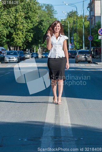 Image of Pretty businesswoman walking on road