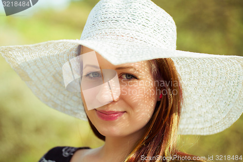 Image of Portrait of cheerful fashionable woman in stylish hat