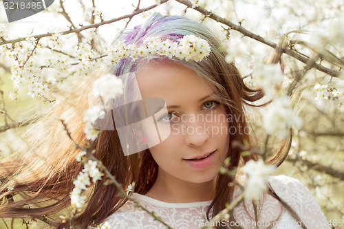 Image of Portrait of cheerful fashionable woman in spring blooming tree