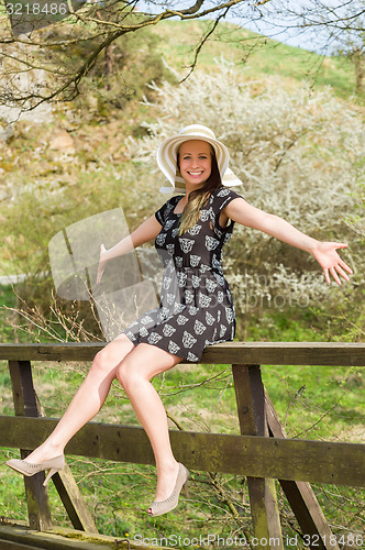 Image of Cheerful fashionable woman in stylish hat and frock posing