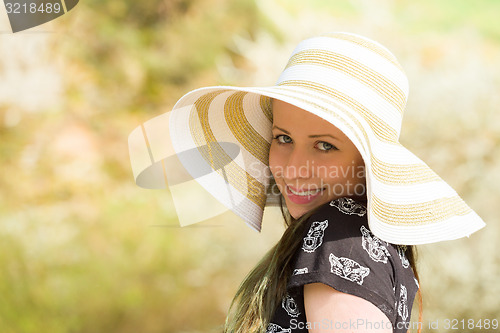 Image of Cheerful fashionable woman in stylish hat and frock posing