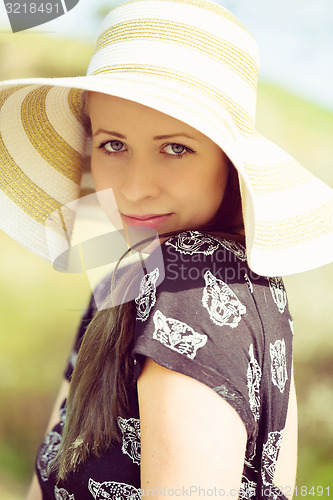 Image of Cheerful fashionable woman in stylish hat and frock posing