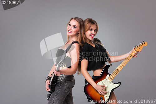 Image of Two beautiful girls playing guitars