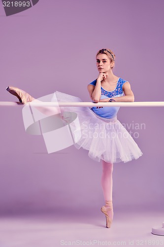 Image of classic ballerina posing at ballet barre