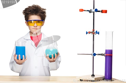 Image of Little boy as chemist doing experiment with chemical fluid in the laboratory