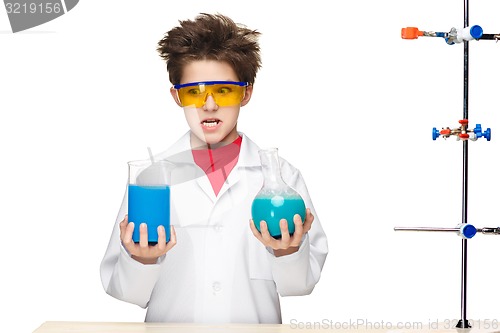 Image of Little boy as chemist doing experiment with chemical fluid in the laboratory