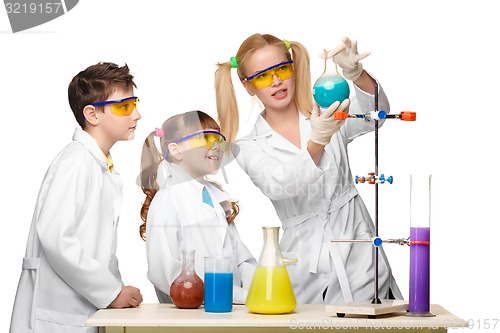 Image of Teens and teacher of chemistry at  lesson making experiments