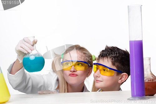 Image of Teen and teacher of chemistry at  lesson making experiments