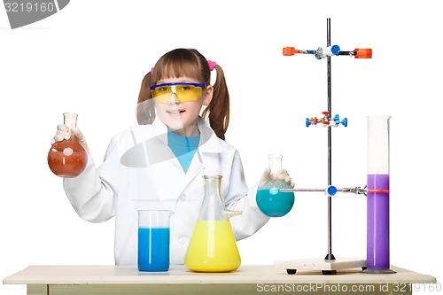 Image of Little girl as chemist doing experiment with chemical fluid in the laboratory