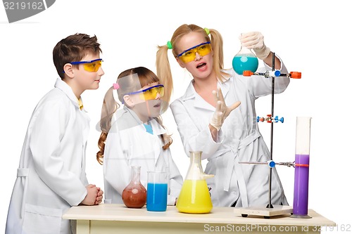 Image of Teens and teacher of chemistry at  lesson making experiments