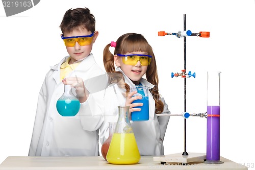 Image of Two cute children at chemistry lesson making experiments