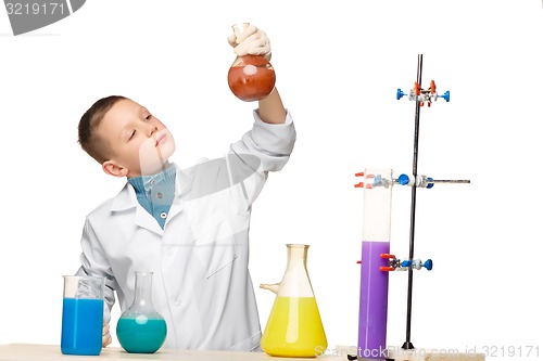 Image of Little boy as chemist doing experiment with chemical fluid in the laboratory