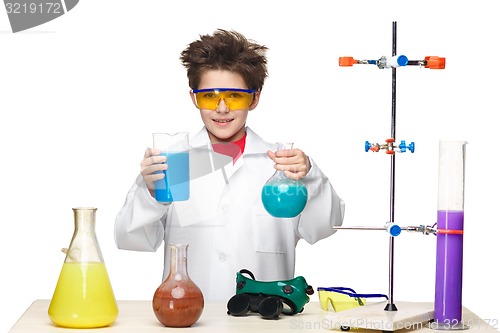 Image of Little boy as chemist doing experiment with chemical fluid in the laboratory