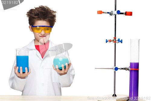 Image of Little boy as chemist doing experiment with chemical fluid in the laboratory